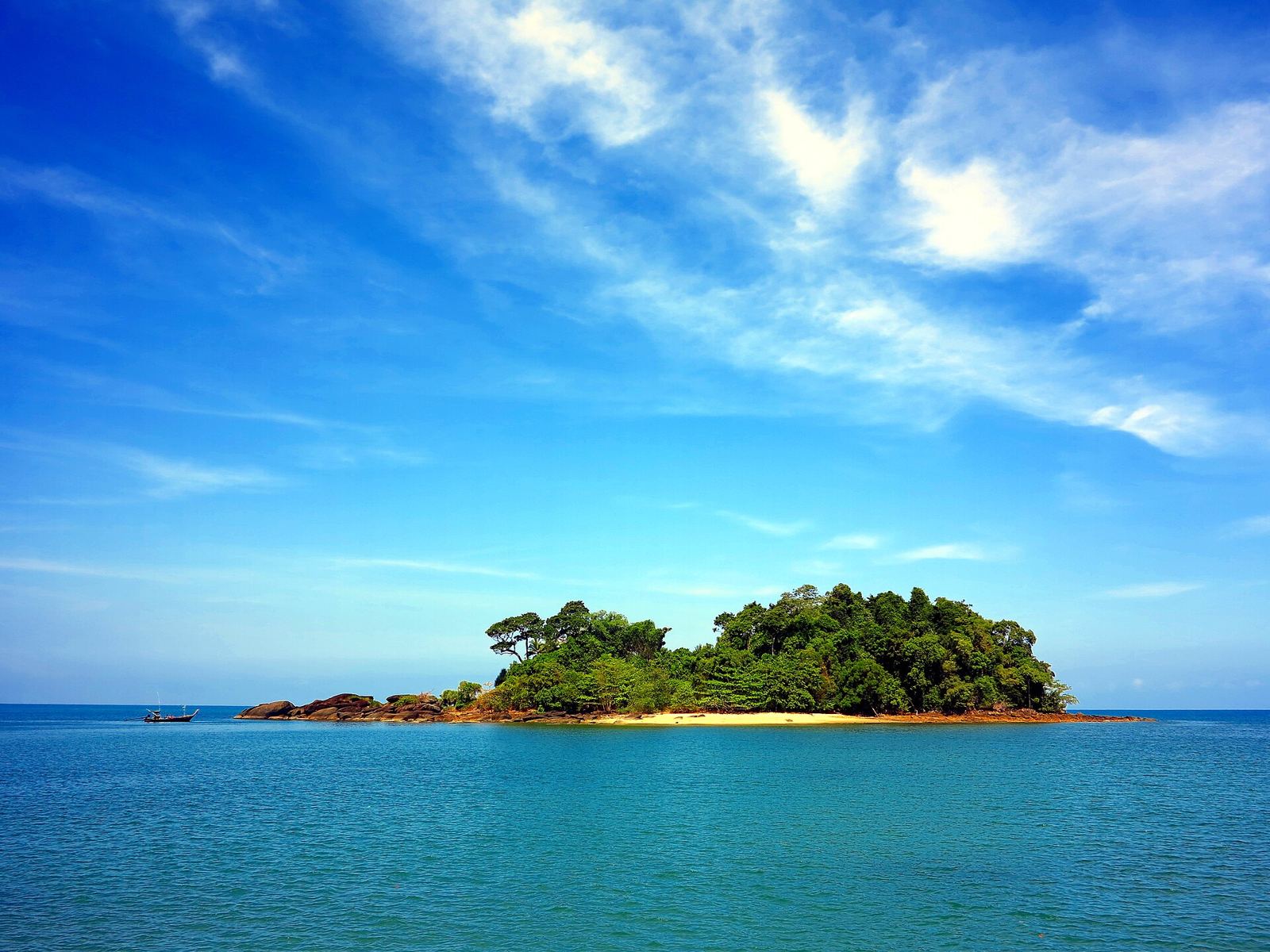 A small green island in a turquoise sea off Thailand